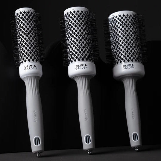 Three hairbrushes with 'Ovalis' branding on a black background